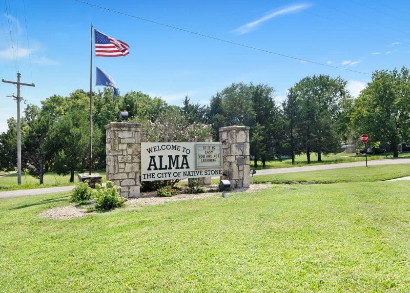 A welcome sign for Alma, Michigan, featuring the city name and nearby flags. A welcome sign for Alma, Michigan, featuring the city name and nearby flags.