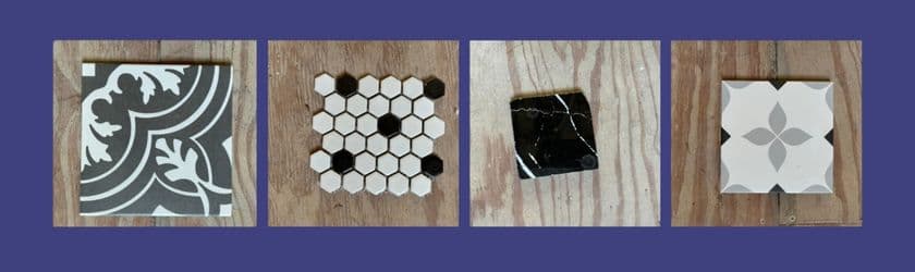 Four decorative tiles displayed on a wooden surface against a blue background.