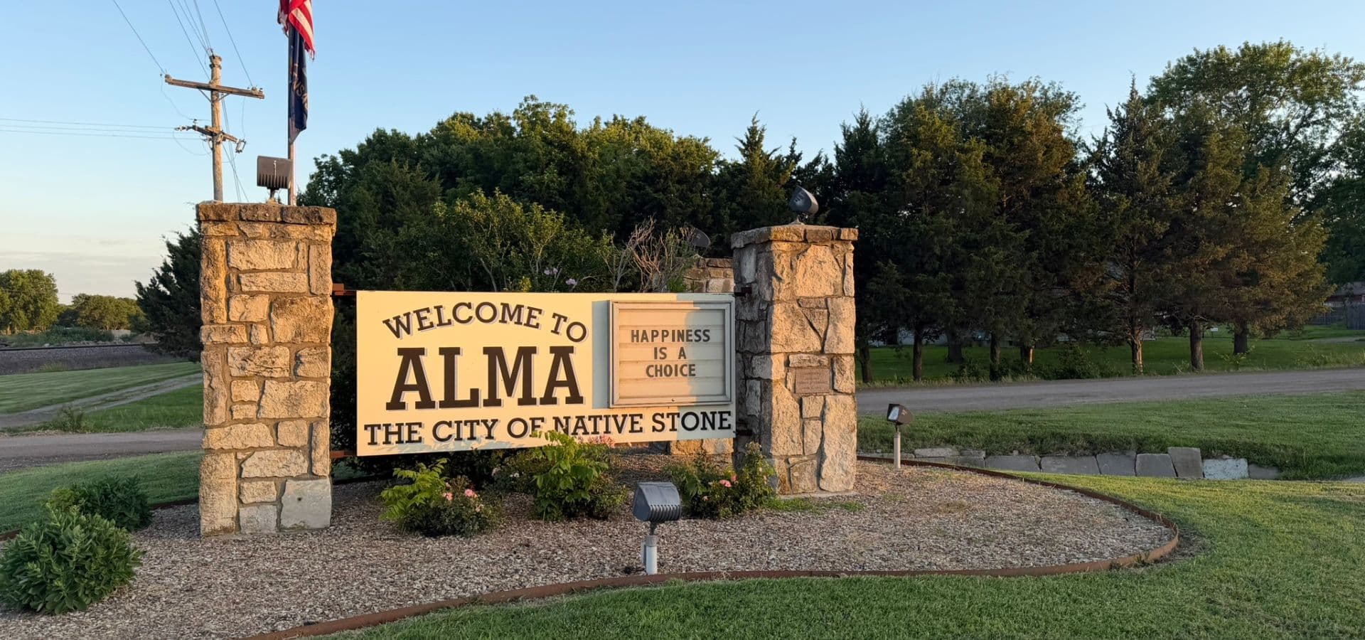 Signpost welcoming visitors to Alma, Kansas, stating "Happiness is a Choice."