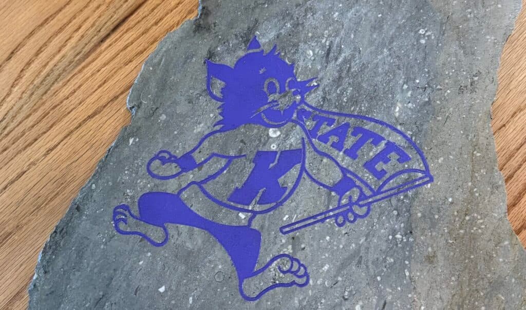 Purple mascot logo on a stone featuring "K-STATE."