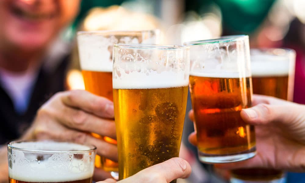 A group of people toasting with glasses of beer.