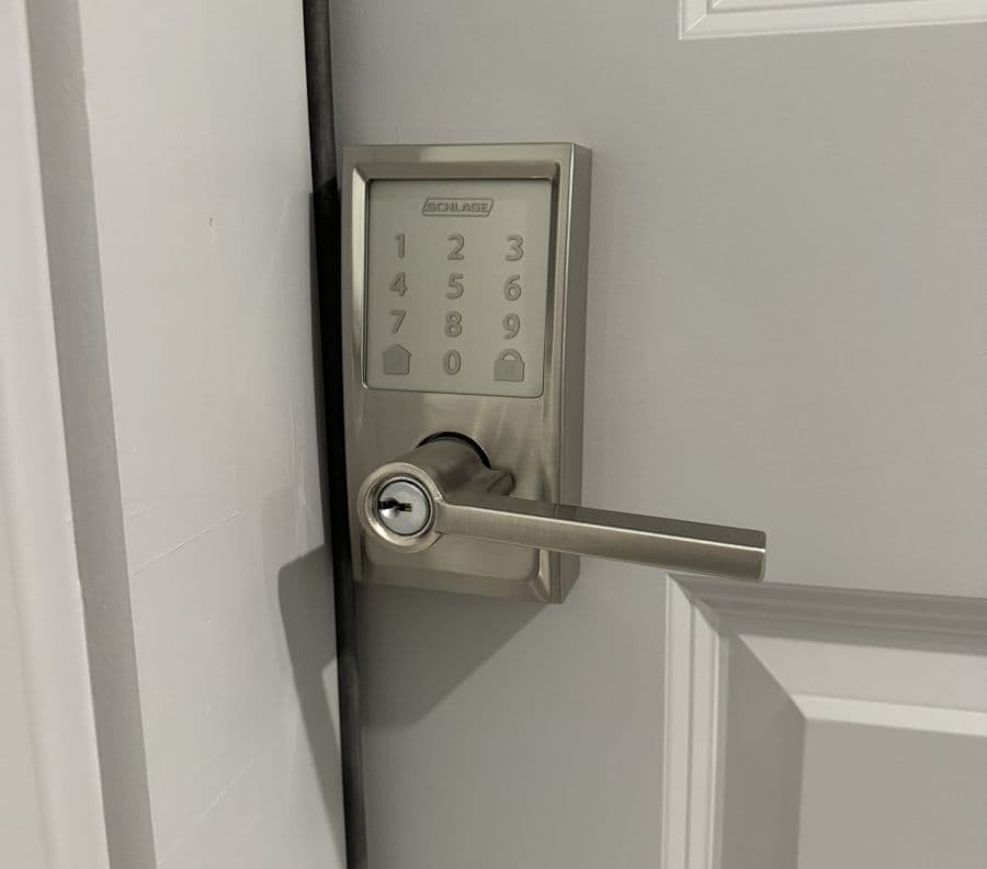 A digital keypad door lock mounted on a gray door. A digital keypad door lock mounted on a gray door.