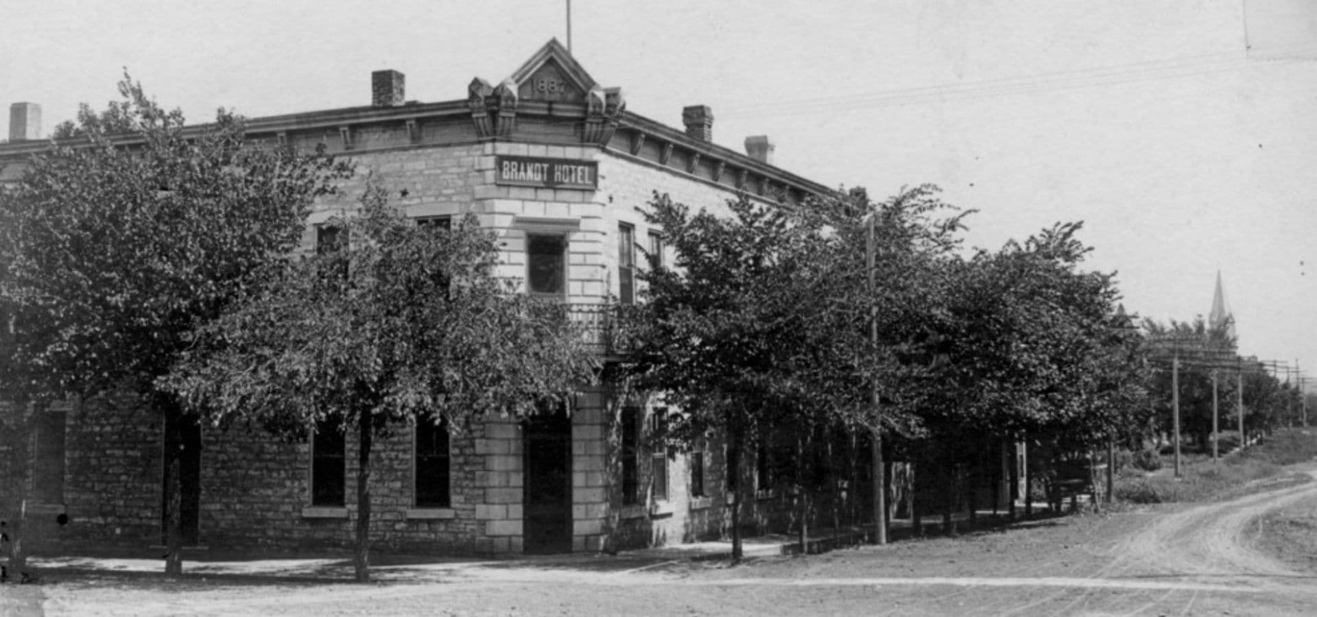 Historic building with trees lining the street in front.