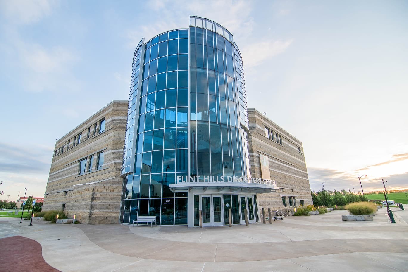 Modern glass and stone building of the Flint Hills Discovery Center at sunset.