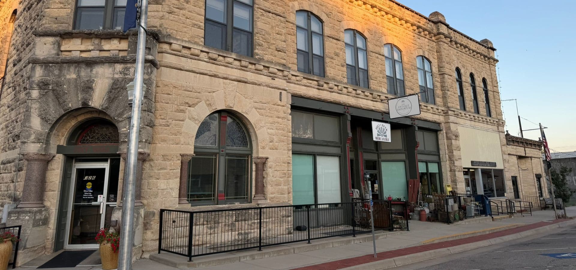Historic stone building with arched windows and a modern storefront.